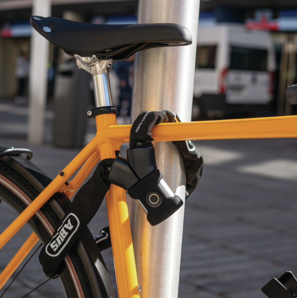 Antivol chaîne ABUS utilisé pour attacher le vélo à un point fixe, assurant une protection fiable contre le vol.